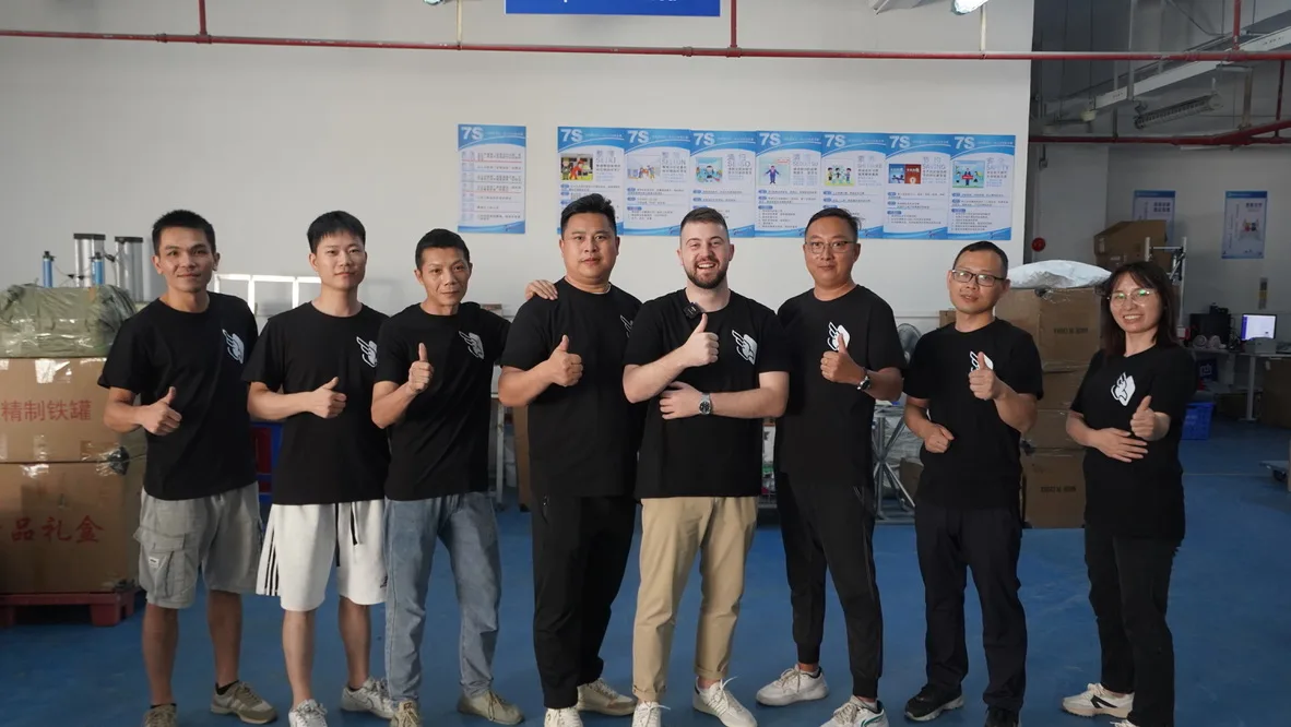 Peregrine Ship Shenzhen team: nine operators in branded t-shirts lined up inside the Bao'an warehouse